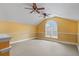 Bonus room with neutral carpet, white trim, arched window, and dual ceiling fans at 5306 Crane Hill Ct, St Cloud, FL 34771