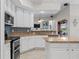 Bright kitchen with white cabinets, granite countertops, island, and stainless steel appliances at 5306 Crane Hill Ct, St Cloud, FL 34771