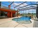 Covered pool area offers an outdoor kitchen, patio seating, and views of the lake at 5306 Crane Hill Ct, St Cloud, FL 34771