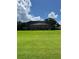 Lush backyard featuring mature landscaping, green lawn, and a large screened-in enclosure at 5416 Bay Side Dr, Orlando, FL 32819