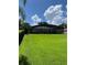 Expansive backyard featuring lush green grass and a screened-in lanai, perfect for outdoor relaxation at 5416 Bay Side Dr, Orlando, FL 32819