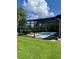View of the screened-in pool and patio area from the backyard with mature trees at 5416 Bay Side Dr, Orlando, FL 32819