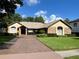Charming single-story home featuring a brick exterior, tile roof, and a well-manicured lawn and landscape at 5416 Bay Side Dr, Orlando, FL 32819