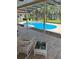 View of the pool and patio from a covered lanai, showcasing a hot tub and lake view at 5416 Bay Side Dr, Orlando, FL 32819