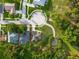 Overhead shot featuring a private backyard pool in a lush yard, complemented by solar panels and mature trees at 544 Lake Sumner Dr, Groveland, FL 34736