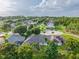 Aerial view showcasing a residential neighborhood with well-maintained homes and mature trees on a sunny day at 544 Lake Sumner Dr, Groveland, FL 34736