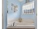 Relaxing tub with decorative starfish and seaside artwork in this bright and airy bathroom at 544 Lake Sumner Dr, Groveland, FL 34736