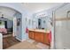 Well-lit bathroom features a double vanity, tile flooring, and glass-enclosed shower at 544 Lake Sumner Dr, Groveland, FL 34736