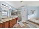 Bright bathroom featuring a shower, separate tub, and double sinks at 544 Lake Sumner Dr, Groveland, FL 34736