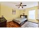 Cozy bedroom with hardwood floors, ceiling fan, and a window allowing natural light at 544 Lake Sumner Dr, Groveland, FL 34736