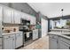 This modern kitchen features stainless steel appliances and white cabinets with dark gray accents at 544 Lake Sumner Dr, Groveland, FL 34736