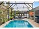Relaxing screened-in pool and spa area with an umbrella-shaded lounge at 544 Lake Sumner Dr, Groveland, FL 34736