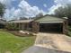 Spacious home with a two-car garage and well-manicured lawn under a cloudy sky at 5935 Sheryl Anita St, Oviedo, FL 32765