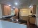 Kitchen featuring classic cabinets, black countertops, and seamless flow to dining area at 5935 Sheryl Anita St, Oviedo, FL 32765