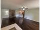 Open living room with hardwood floors and a brick fireplace, flowing into the kitchen at 5935 Sheryl Anita St, Oviedo, FL 32765