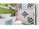 Bathroom featuring a white vanity with a unique bowl sink, a black and white tiled shower, and green walls at 638 Clayton St, Orlando, FL 32804