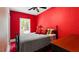 Bedroom with bold red walls, a black metal bed frame, and a ceiling fan enhancing the room's style at 638 Clayton St, Orlando, FL 32804