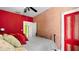 View of a bedroom with red and tan painted walls, a black bed, and a red door at 638 Clayton St, Orlando, FL 32804
