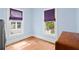 Bedroom with blue walls, wooden floors, a vintage dresser and natural light from the two windows at 638 Clayton St, Orlando, FL 32804