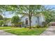 Well-maintained light blue home with beautiful landscaping and mature shade tree at 638 Clayton St, Orlando, FL 32804