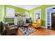 Green living room featuring hardwood floors, white fireplace, large windows and comfortable seating at 638 Clayton St, Orlando, FL 32804