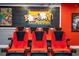 Home theater in basement with tiered seating, projector, and a themed concession stand area at 8102 Pomo Dr, Kissimmee, FL 34747