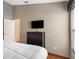 Bedroom features a dresser with a TV, white quilt and wood-look floors at 8102 Pomo Dr, Kissimmee, FL 34747