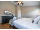 Bedroom features a ceiling fan, TV, dresser and a quilt covered queen bed at 8102 Pomo Dr, Kissimmee, FL 34747