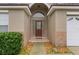 Inviting front porch with a decorative glass door, enhanced by manicured landscaping and stone accents at 8102 Pomo Dr, Kissimmee, FL 34747