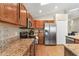 Well-lit kitchen features granite counters, stainless steel appliances, and wood cabinets at 8102 Pomo Dr, Kissimmee, FL 34747