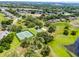 Aerial shot of a lush green community featuring a lake, tennis courts, a playground, and well-maintained landscaping at 8122 Westminster Abbey Blvd, Orlando, FL 32835