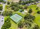Aerial shot of tennis courts and a playground nestled within a lush green community with mature trees and landscaping at 8122 Westminster Abbey Blvd, Orlando, FL 32835