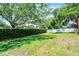 Spacious backyard featuring a well-maintained lawn, privacy hedge, and a play set, perfect for outdoor activities at 8122 Westminster Abbey Blvd, Orlando, FL 32835