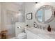 Updated bathroom featuring a glass-enclosed shower and round mirror above the sink and vanity at 8122 Westminster Abbey Blvd, Orlando, FL 32835
