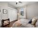 This cozy bedroom boasts neutral paint, wood floors, and a light-filled window with white curtains at 8122 Westminster Abbey Blvd, Orlando, FL 32835