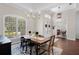 Bright dining room with a wood table, decorative rug, and a view of the front yard at 8122 Westminster Abbey Blvd, Orlando, FL 32835