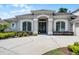 Inviting front entrance with a gray facade, arched doorway, and decorative glass doors at 8122 Westminster Abbey Blvd, Orlando, FL 32835