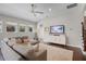 Bright living room with a comfortable gray sofa, a large TV, and plenty of natural light at 8122 Westminster Abbey Blvd, Orlando, FL 32835