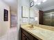 Bathroom vanity with large mirror, framed art, decorative wall hangings, and tile floors at 8346 Mattituck Cir, Orlando, FL 32829
