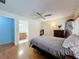 Bedroom with wood floors, comfortable bed, ceiling fan, and en suite bathroom at 8346 Mattituck Cir, Orlando, FL 32829