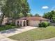 Inviting home featuring a well-manicured lawn, lush landscaping, and a convenient two-car garage at 8346 Mattituck Cir, Orlando, FL 32829