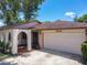 Charming house featuring a two-car garage, and unique archway at 8346 Mattituck Cir, Orlando, FL 32829