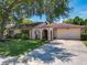 Charming single-story home featuring a spacious driveway, manicured lawn, and unique architectural details at 8346 Mattituck Cir, Orlando, FL 32829