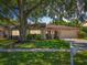 Well-maintained single-story home with lush green lawn and mature trees at 8346 Mattituck Cir, Orlando, FL 32829