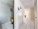 Hallway featuring tile flooring, leading to a half bathroom and other areas of the home at 8346 Mattituck Cir, Orlando, FL 32829
