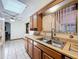 Galley-style kitchen offers a skylight, plenty of counter space and wood cabinets at 8346 Mattituck Cir, Orlando, FL 32829