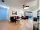 Bright living room featuring skylight, wood floors, stylish sofas, and seamless access to the sunroom at 8346 Mattituck Cir, Orlando, FL 32829