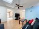 Inviting living room with a skylight, ceiling fan, wood floors, and comfortable seating arrangement at 8346 Mattituck Cir, Orlando, FL 32829