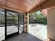 Cozy, covered outdoor patio with brick floor, shelving, and a fire pit surrounded by lush greenery at 8346 Mattituck Cir, Orlando, FL 32829