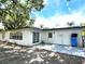 Back of house with back door, sliding glass doors and shaded patio at 9148 Oakwood Dr, Lake Wales, FL 33898
